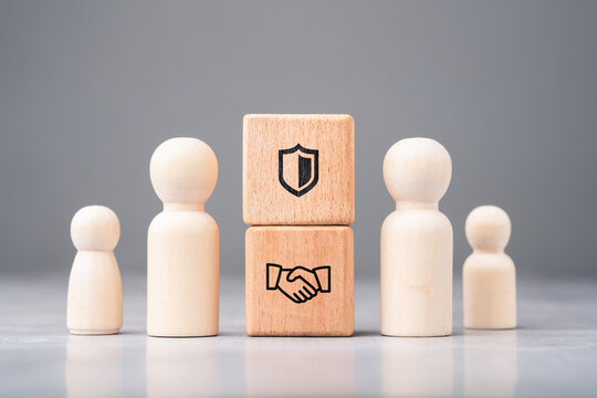 Wooden figures with handshake and shield icons representing trust, secure partnership, and reliable business relationships