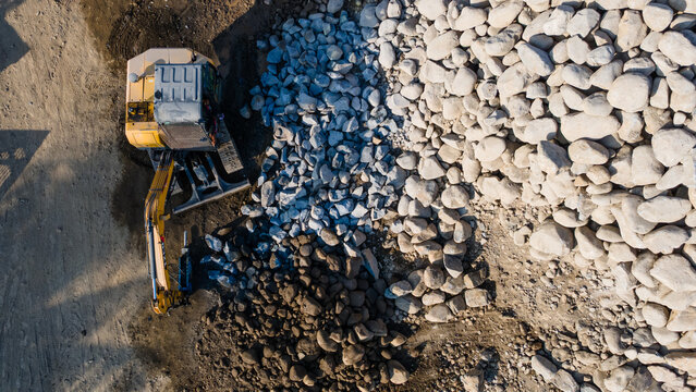 Aerial Scenery of Excavator Operating in Rock Quarry Mine with Gravel and Boulder Extraction, Construction and mining site view from above 