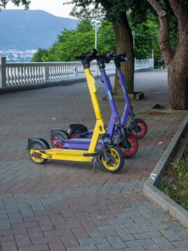 Electric Scooters Parked on Cobblestone Path