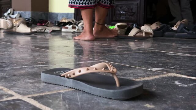 Da nang, lady buddha, footwear gathered outside a traditional building entrance, symbolising cultural customs and respect for sacred spaces