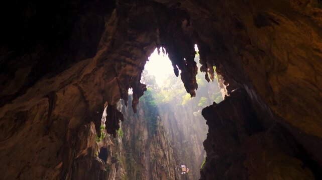 Rays of sunlight entering Batu Caves at Kuala Lumpur, Malaysia. Ancient limestone formation at opening of cave. Famous landmark of Malaysia.  Travel and holidays concept. 