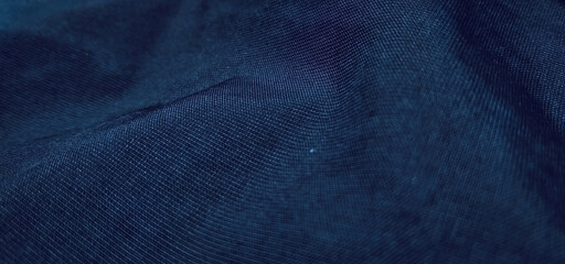 Dark blue fabric texture with soft wavy folds and dim lighting, creating an elegant and calm abstract backdrop © wiki