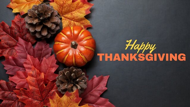 Autumn arrangement featuring a small pumpkin maple leaves and pinecones on a dark background fall thanksgiving leaf pinecone