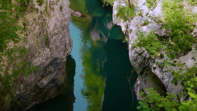 Sentiero del Dint view of steep limestone canyon cliffs covered in lush green summer foliage, Italy.