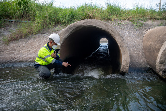 Professional Engineer Inspecting Drainage Pipe for Water Management Infrastructure Assessment