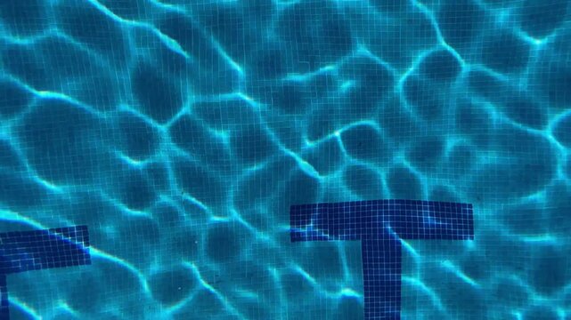 Abstract blue pool water with rippling light patterns and tiles