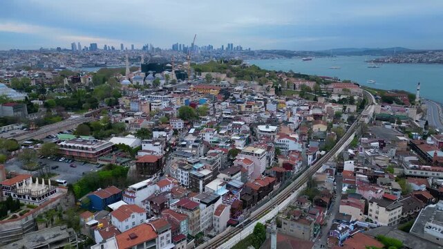 Istanbul cityscape with Blue Mosque and Hagia Sophia domes, minarets, historical buildings, and the Bosphorus strait. Smooth aerial view fly reverse drone panorama
