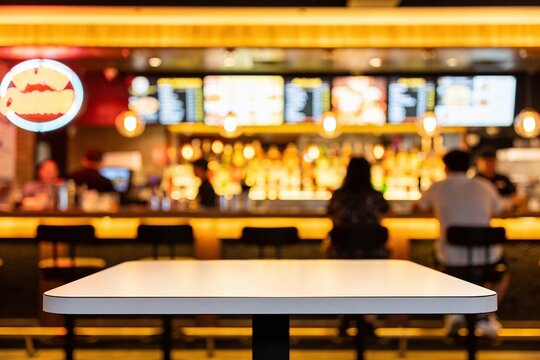 Tabletop surface sits in the foreground of a blurred restaurant interior with people dining at a bar.