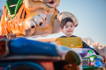 Smiling boy riding colorful fairground carousel with giant tiger figure © Oleksii Yemelianov