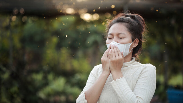 Woman Wearing Protective Mask Coughing Outdoors in Dust Pollution for Allergy Concept