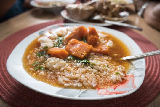 A plate of tomato soup with rice.
