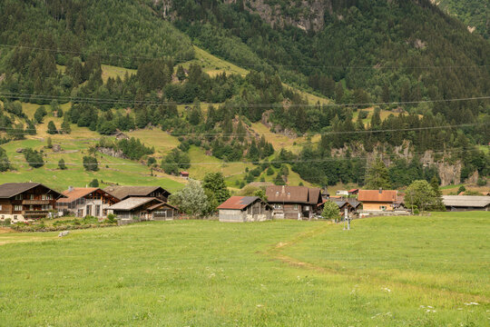 Guttannen, Switzerland. Traditional Swiss alpine village with wooden chalets and green mountain landscape in the Bernese Oberland