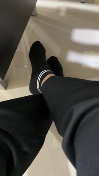 a pair of feet in socks relaxing under the desk