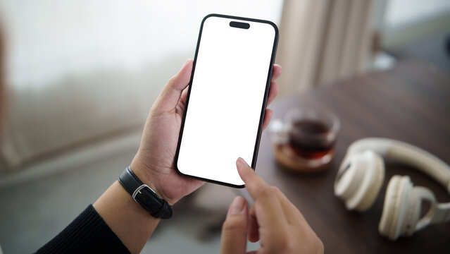 Close up of hands holding smartphone with blank white screen, perfect for mobile app mockup or digital interface design.