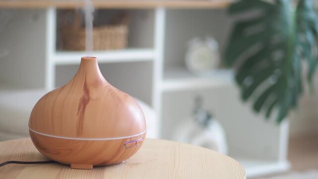 A wooden aroma diffuser emits a continuous stream of steam, creating a soothing and tranquil atmosphere in a cozy room, footage