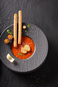 Exquisite and tasty tomato soup decorated with crostini and spices.