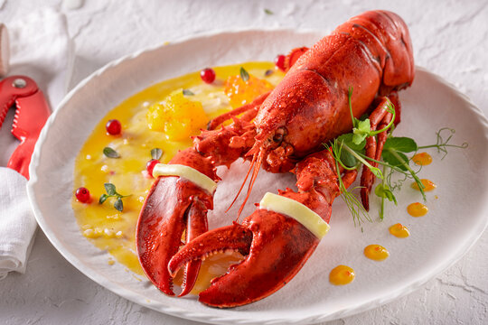 Professional boiled lobster served with tongs and hammer.