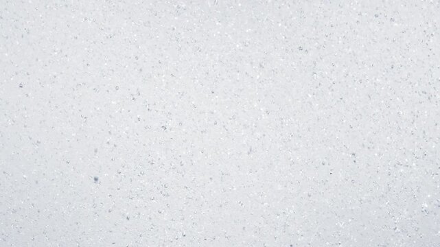 Abstract close up of falling water droplets creating dynamic splashes and bubbles. Refreshing rainfall or tropical shower background with fluid motion and natural texture