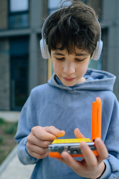 Teenager outdoors listens to music with a retro cassette player