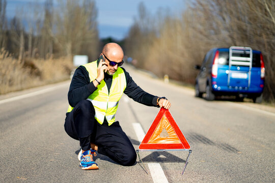 Man using a smartphone having a car breakdown