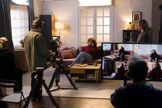 Crew filming an actress during a studio production