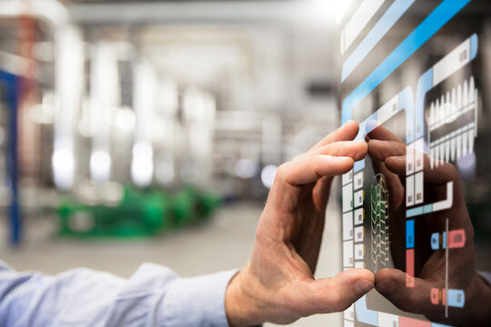 Man using touchscreen device in industrial plant