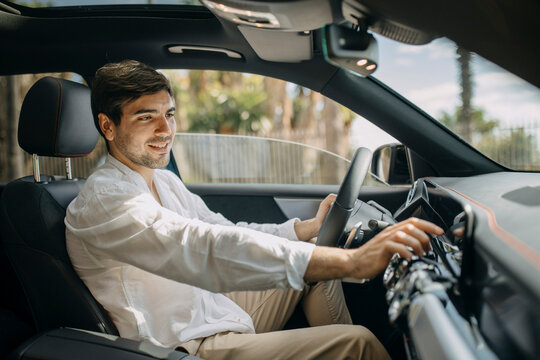 Young man using control panel of electric car