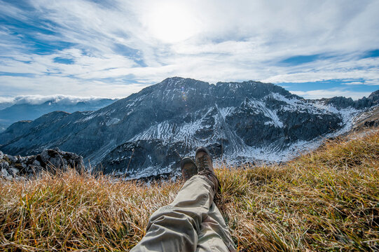 Austria, Salzburg State, Altenmarkt-Zauchensee, man's legs in front of snow-capped cirque