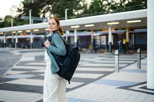 Businesswoman walking with backpack at train station