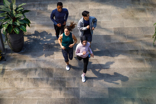 Friends running together on footpath