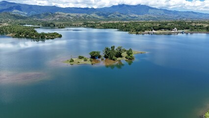 Fototapeta premium Aerial View of Crystal Clear Tropical Lake with Small Island and Mountain Landscape