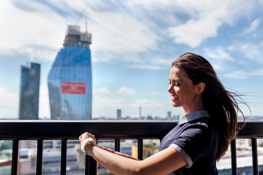 UK, London, smiling woman using smartwatch on a roof terrace