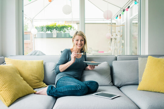 Portrait of happy woman relaxing on couch
