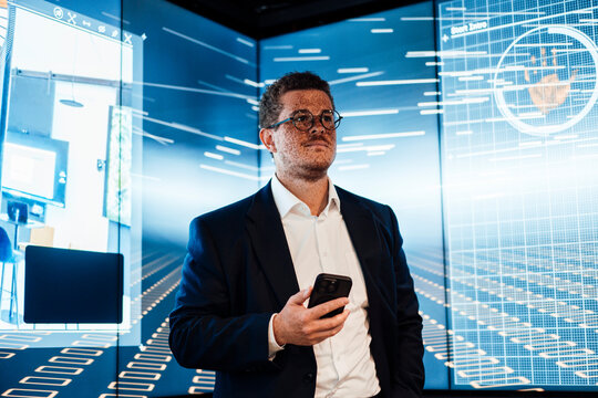 Businessman holds a smartphone in a modern television studio