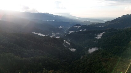 Aerial View of Sunrise Over Misty Tropical Mountain Valley and Lush Rainforest © Alsy