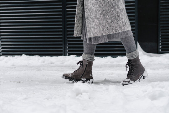 Woman wearing snow boots walking on footpath