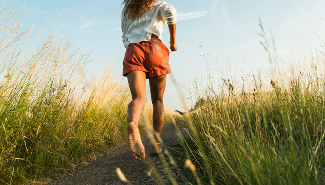 Young woman running on path in field