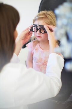 Eye doctor examining girl's vision