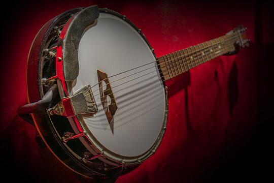 Dark Wood Banjo Against Rich Red Background