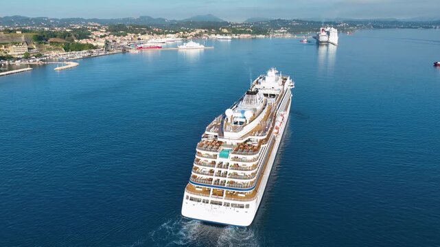 Breathtaking aerial drone footage following the stern of the Viking Vesta luxury cruise ship as it navigates the waters near Corfu, Greece. The shot highlights the ship's aft infinity pool and beautif