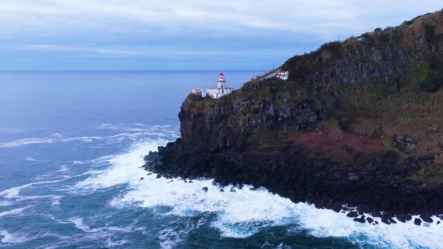 Strong Waves Hitting The Coastline Of Ponta Do Arnel Lighthouse At Sunrise In Sao Miguel, Azores, Portugal. - aerial shot