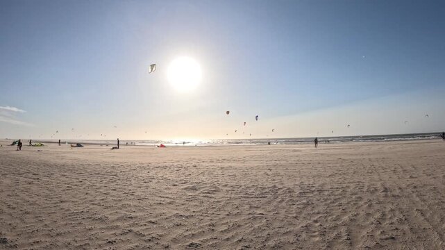 Golden hour kitesurfing at Kijkduin Beach featuring vibrant sunset skies, rolling North Sea waves and exciting coastal action