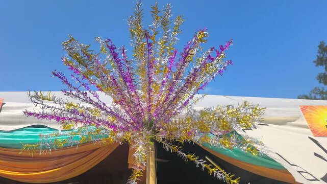 Colorful bunga manggar poles sway beautifully. This traditional Malay cultural ornament is widely used in wedding processions. It adds a festive and vibrant atmosphere to the celebration.