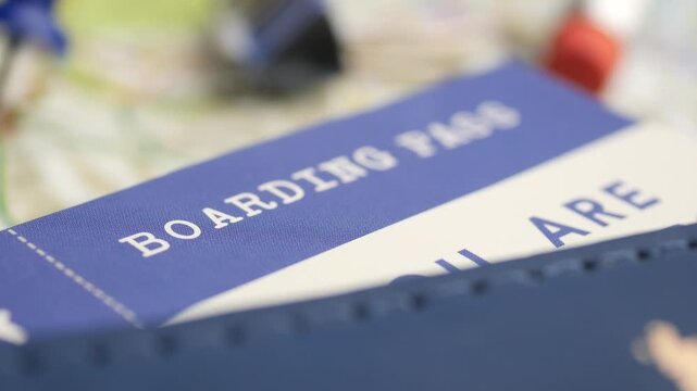 Close up cinematic footage of blue boarding pass and passport on map background with shallow depth of field
