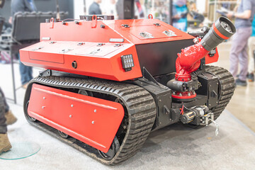 Firefighting robot on display, mounted turret camera, rugged tracks for terrain use, red black color contrast, professional commercial style, sharp focus equipment © Mister