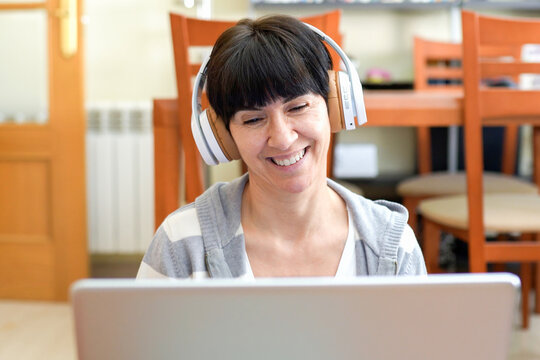 Confident woman leading online session. Woman with headphones engaging in virtual coaching
