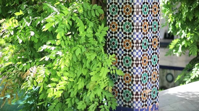 Lush greenery and colorful mosaic columns in the garden courtyard of the Grand Mosque of Paris