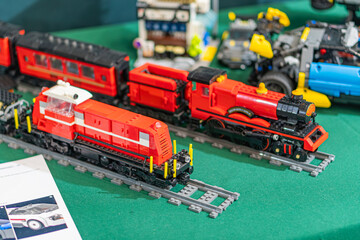 Fototapeta premium Lego train set on green tablecloth with red and black trains arranged meticulously - Kyiv, Ukraine - June 7, 2025