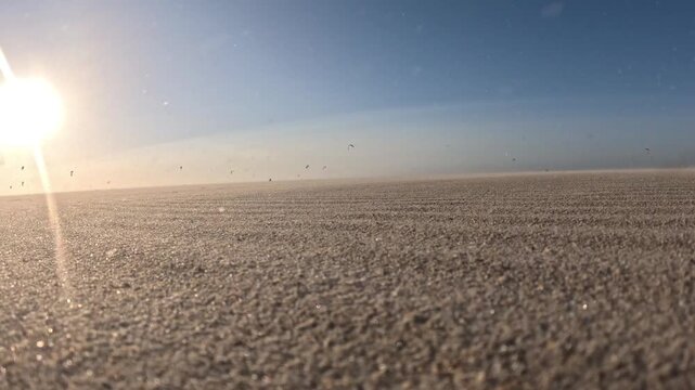Peaceful yet dramatic sunset at Kijkduin Beach with kitesurfers beyond a windswept sandy shoreline