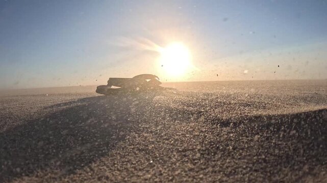 Immersive sunset scene at Kijkduin Beach with flip-flops, blowing sand and distant kitesurfers creating a dramatic coastal atmosphere